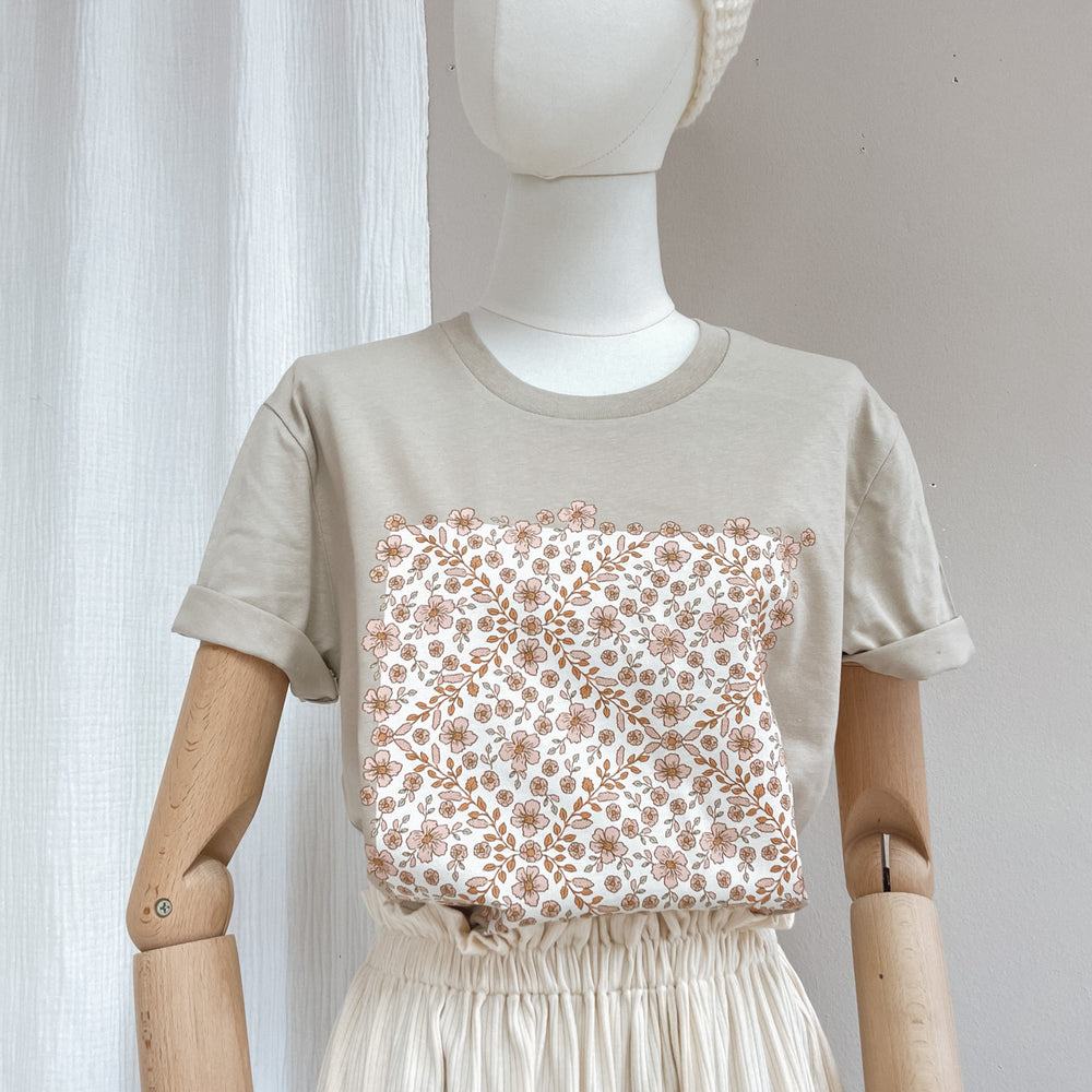 
                      
                        T-shirt / floral garland / sand
                      
                    