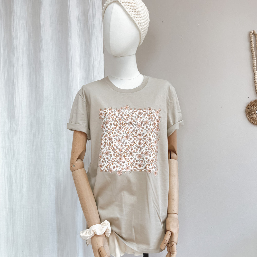 
                      
                        T-shirt / floral garland / sand
                      
                    